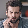 Man holding jaw in pain