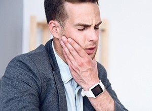 Man holding jaw in pain