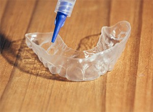 A custom-made whitening tray and a syringe.